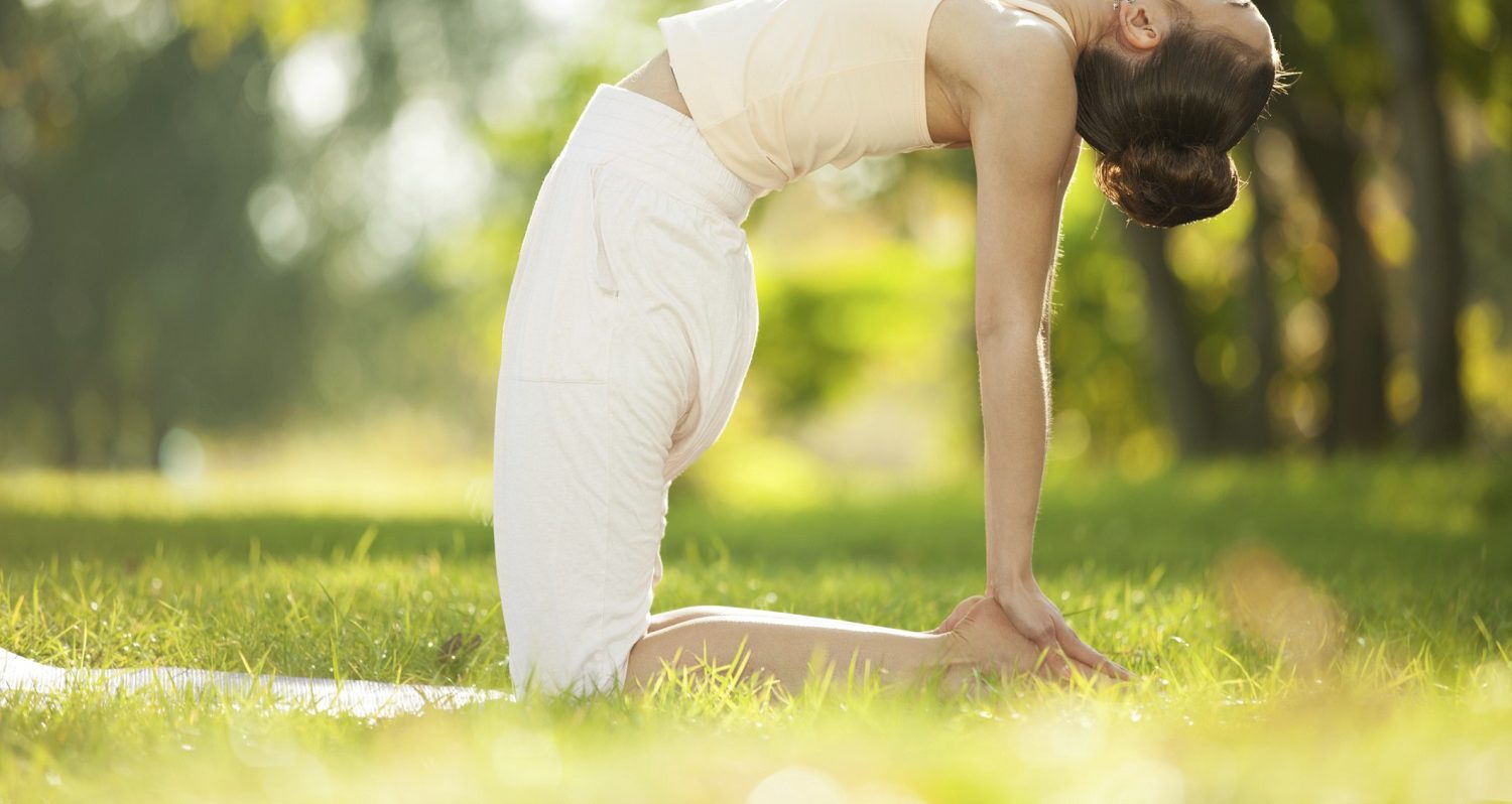 woman doing yoga in the grassy hills