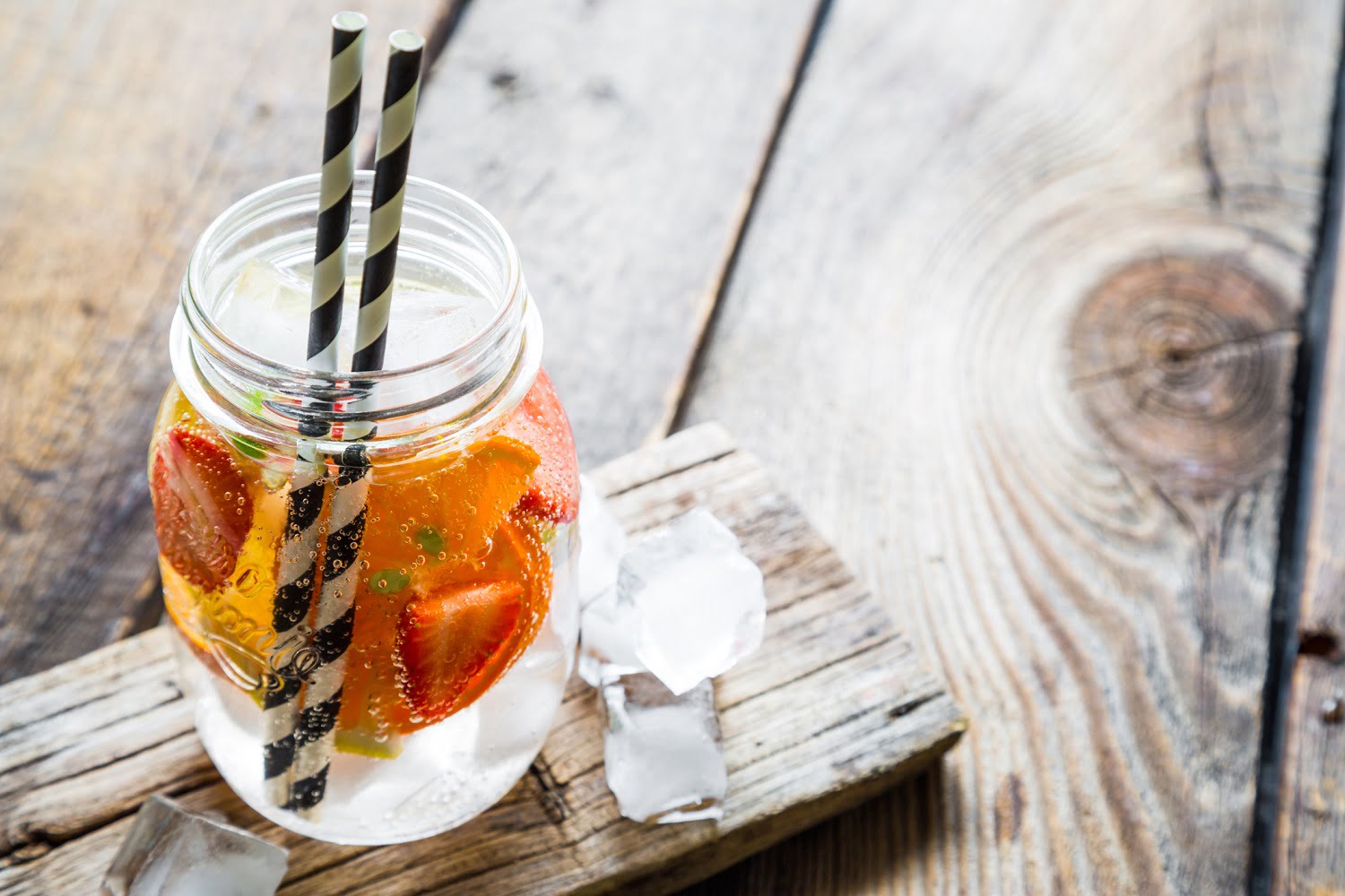 drink with strawberries in a mason jar