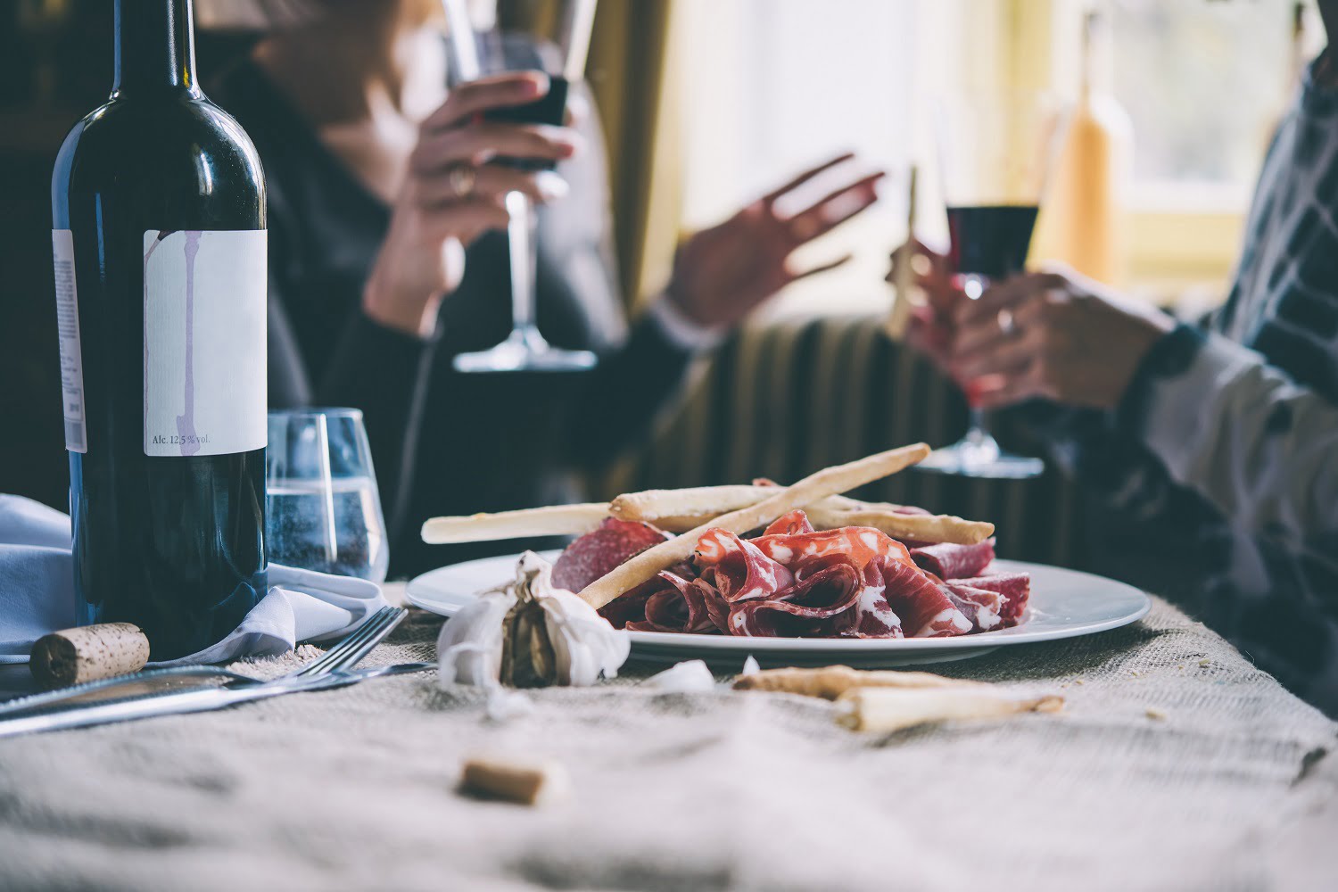 people drinking wine at restaurant with appetizers