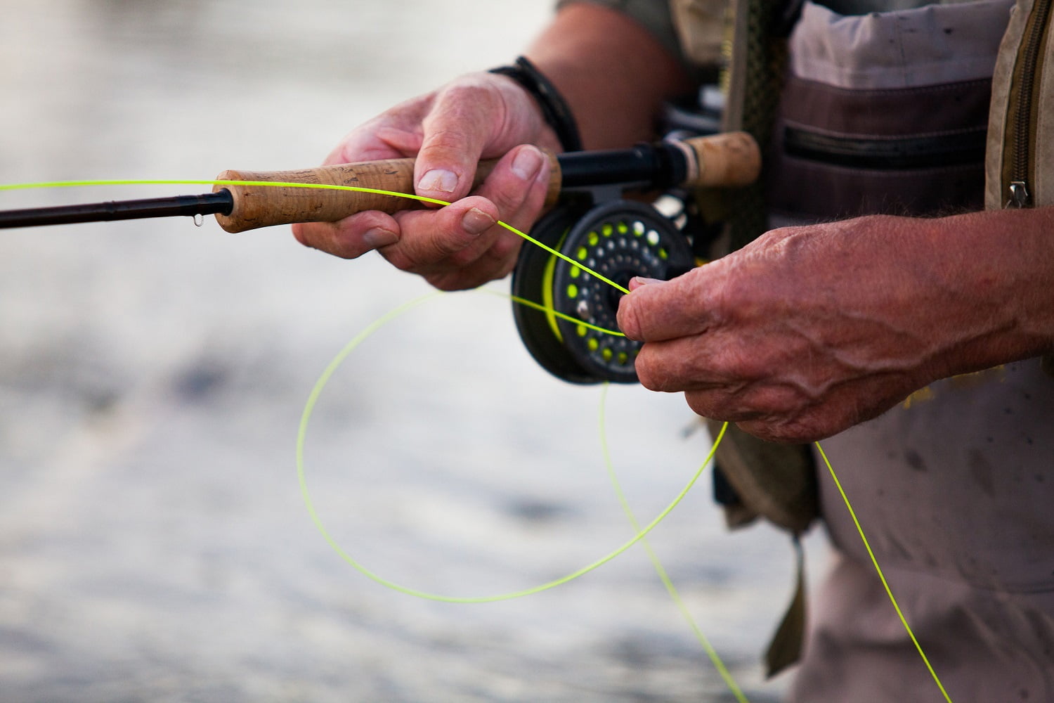 Elderly man fly fishing in a river