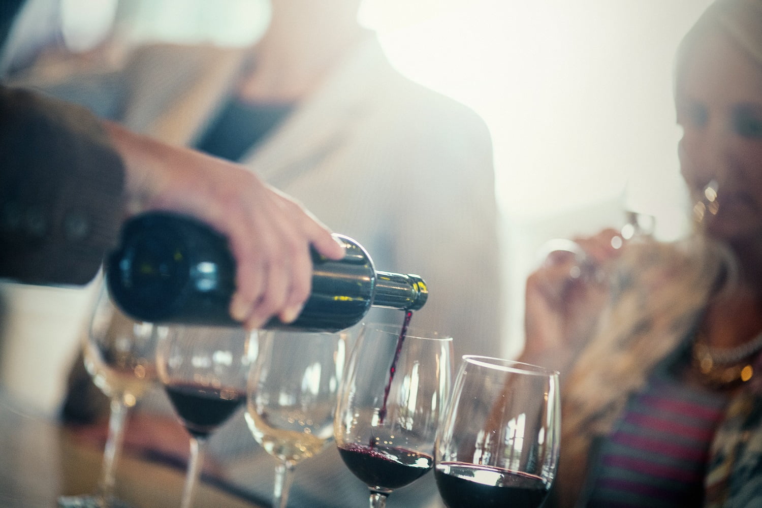 bartender pouring various wines for wine tasting