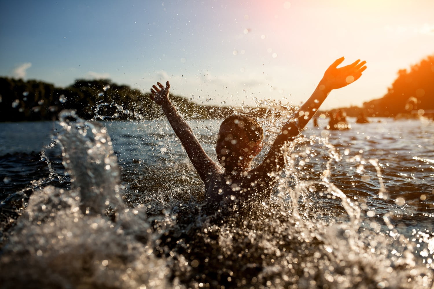 child splashing around in a lake