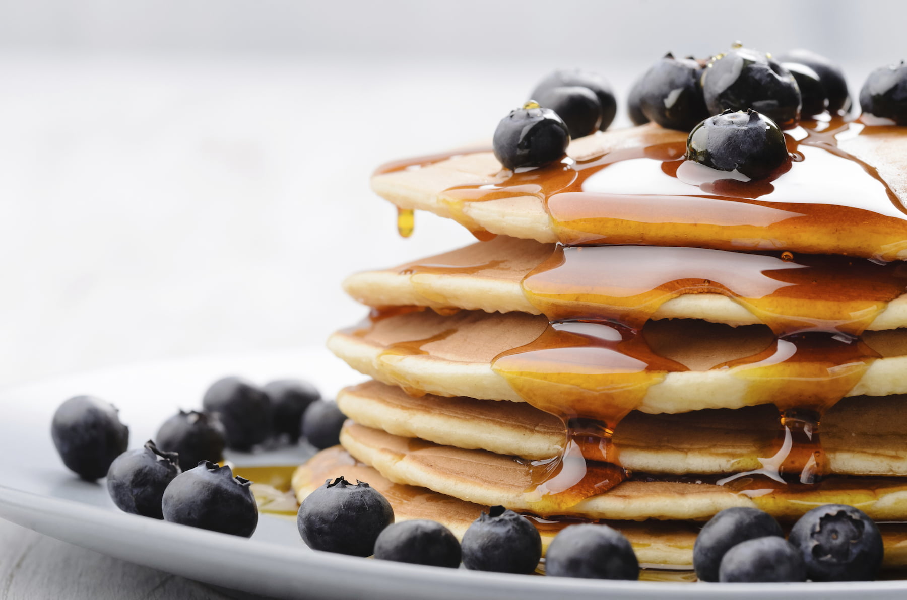 Stack of pancakes with syrup and blueberries