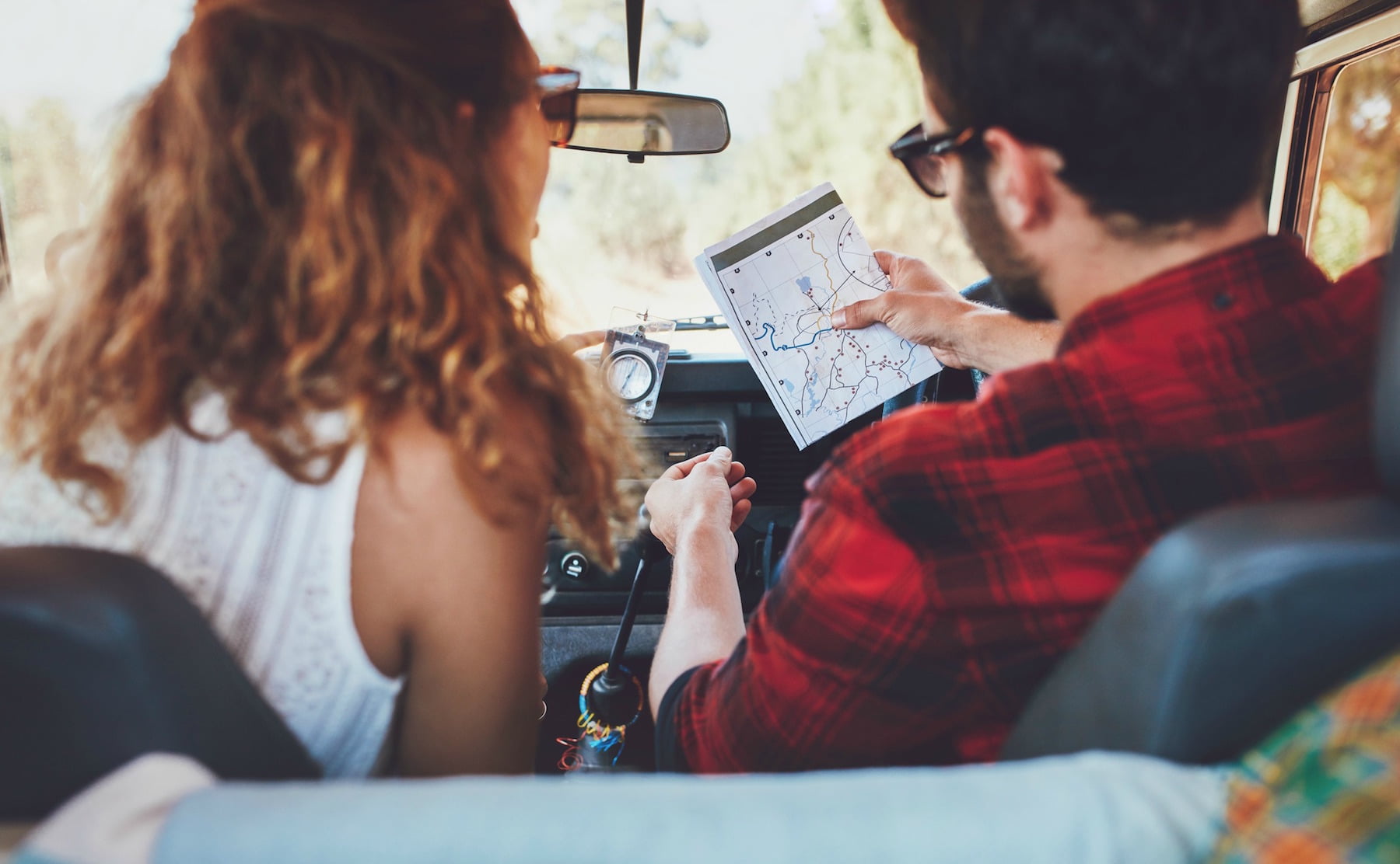 Young couple checking their map on a road trip.